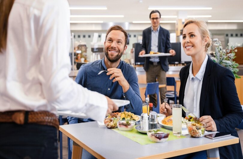 Mann und Frauen essen Mittag in Kantine
