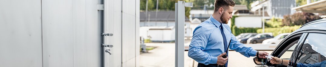Sicherheitsfachkraft mit Headset vor Monitor im Bereich Sicherheitsdienst, Sicherheitstechnik