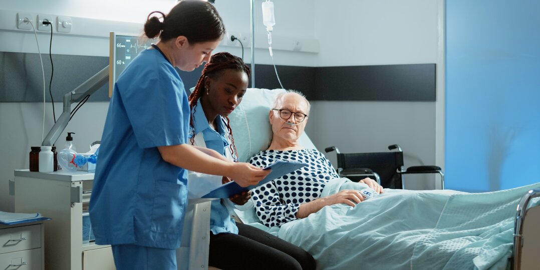 Dussmann Lavador Wäscheservice erfüllt die strengen Normen des medizinischen Sektors, garantiert eine optimale Desinfektion der Krankenhauswäsche und eine einwandfreie Qualität zum Schutz der Patienten und des Pflegepersonals. | © <a href="https://www.freepik.com/free-photo/african-american-doctor-talking-sick-patient-bed-hospital-ward-treating-health-problems-injury-old-man-asking-medic-nurse-about-intensive-care-illness-recovery_20717490.htm">Image by DC Studio on Freepik</a>