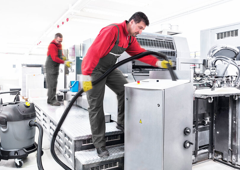 Reinigungskraft reinigt Industrieanlage